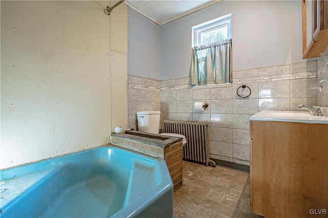 full bath featuring vanity, tile walls, a bath, and radiator heating unit