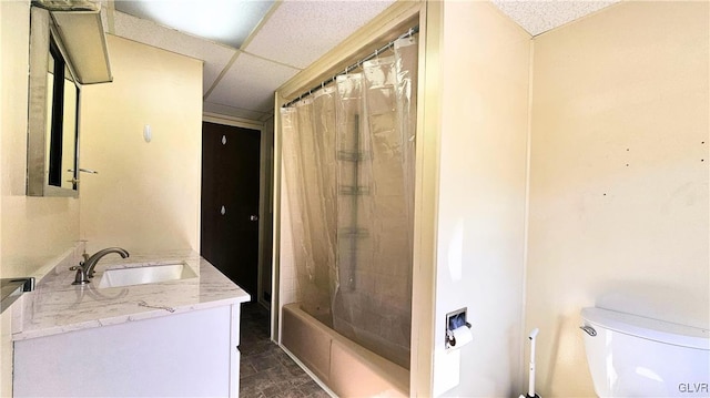 full bath with shower / bath combo with shower curtain, a drop ceiling, toilet, and vanity