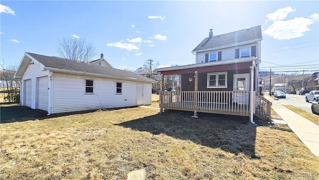 rear view of house featuring a lawn, a porch, and an outdoor structure