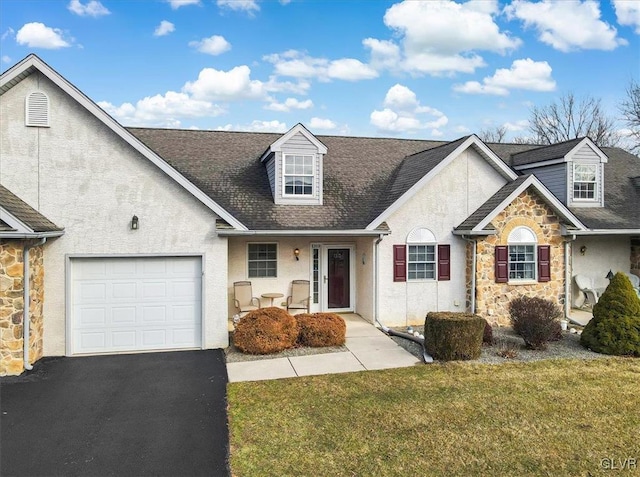 view of front of home with stucco siding, driveway, a front lawn, stone siding, and an attached garage