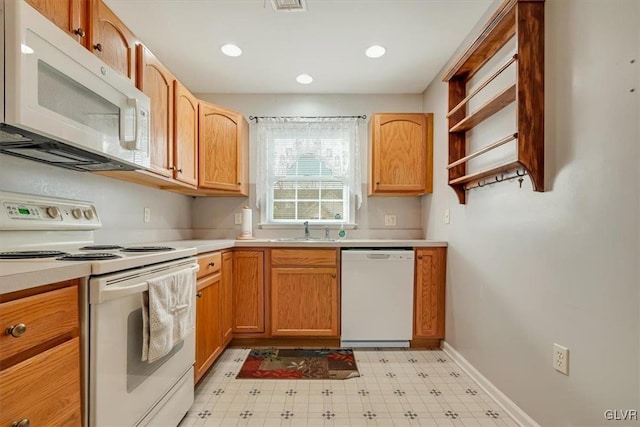 kitchen with white appliances, light floors, baseboards, a sink, and light countertops