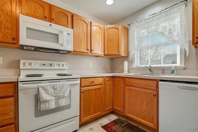 kitchen with light floors, white appliances, light countertops, and a sink