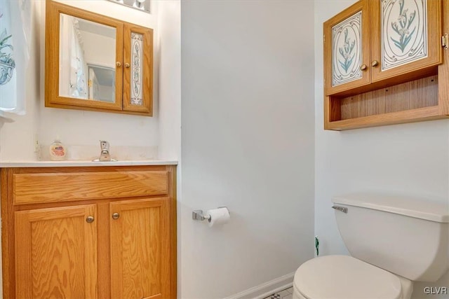 bathroom featuring vanity, toilet, and baseboards