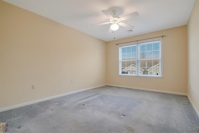 spare room with carpet flooring, visible vents, baseboards, and ceiling fan