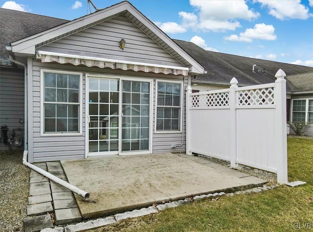 back of property featuring a patio area, fence, and a shingled roof