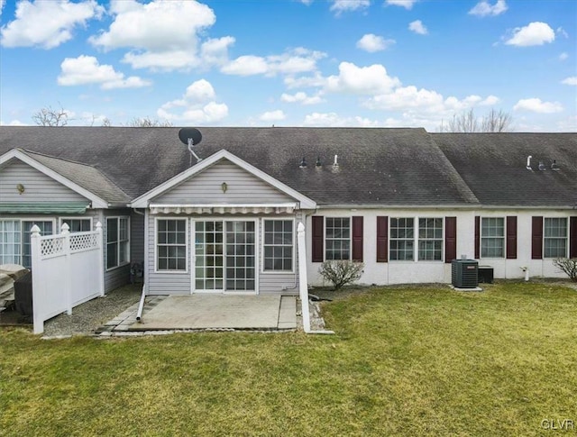 back of property featuring a shingled roof, fence, central AC, a yard, and a patio area