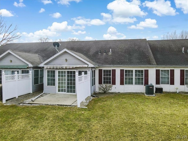 back of property featuring central air condition unit, a patio, a lawn, and fence