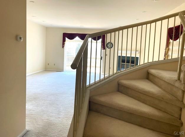 staircase with baseboards and carpet floors