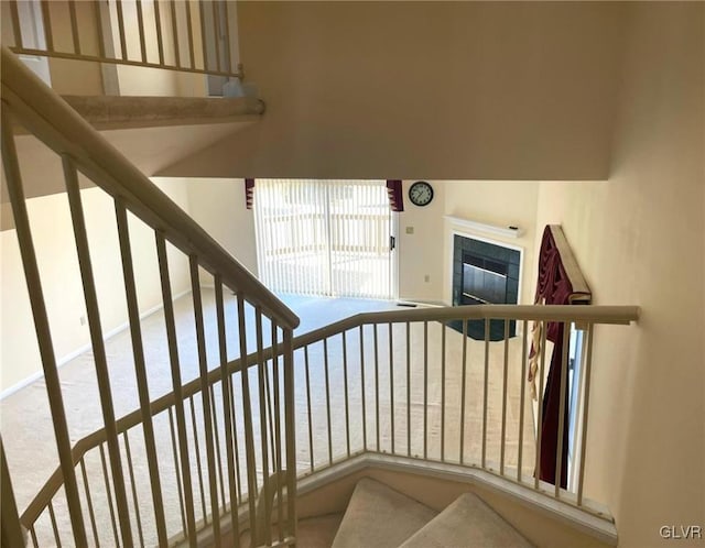 stairs with a tiled fireplace