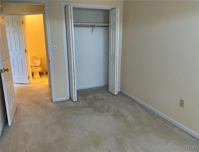 unfurnished bedroom featuring carpet flooring, baseboards, and a closet