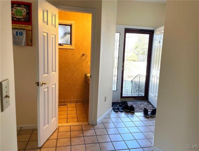 entrance foyer with light tile patterned floors and baseboards