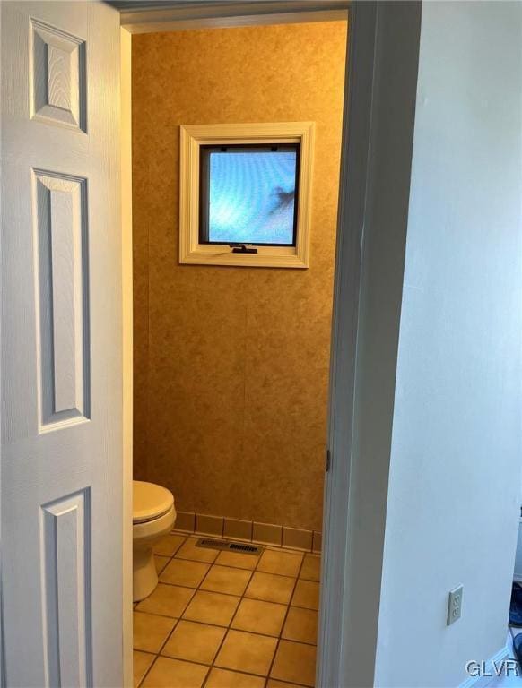 bathroom with tile patterned floors, toilet, and baseboards