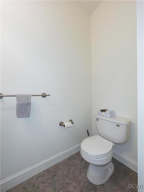 bathroom with baseboards and toilet