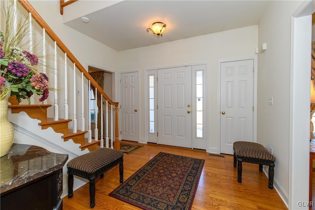 entrance foyer featuring stairs and light wood-type flooring