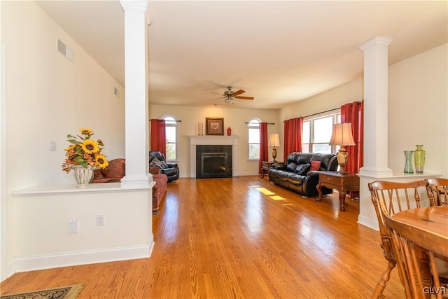 living room with visible vents, ornate columns, and light wood-type flooring