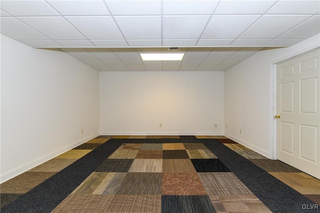 spare room with a paneled ceiling and baseboards