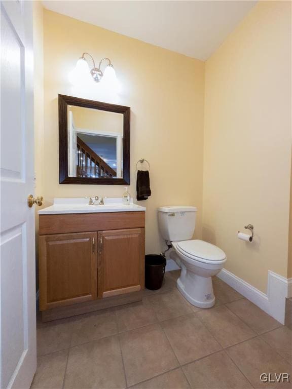 bathroom featuring vanity, tile patterned floors, toilet, and baseboards