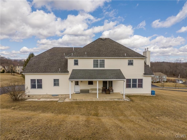 back of property featuring a patio, a lawn, and a shingled roof