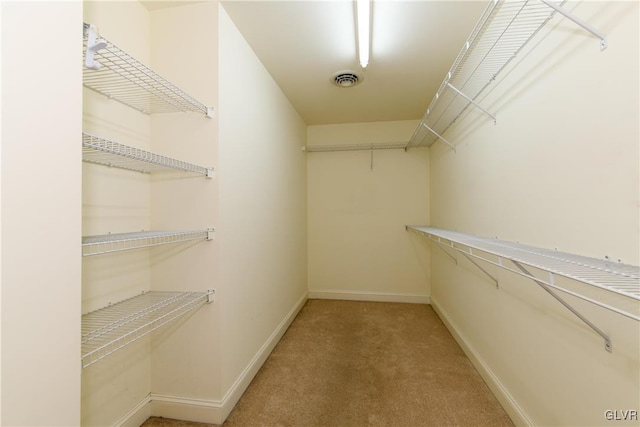 walk in closet featuring visible vents and light colored carpet