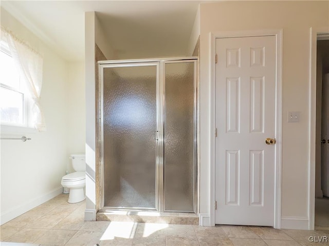 bathroom featuring tile patterned floors, a shower stall, toilet, and baseboards