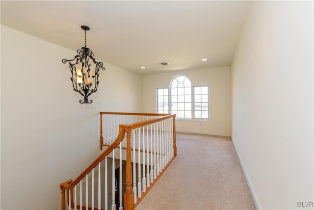 corridor with baseboards, light colored carpet, an upstairs landing, recessed lighting, and an inviting chandelier