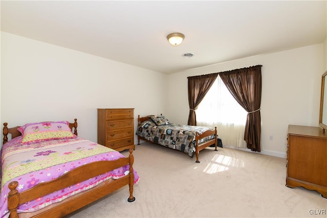 carpeted bedroom featuring baseboards and visible vents