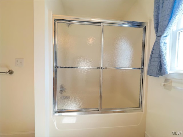 bathroom with shower / bath combination with glass door