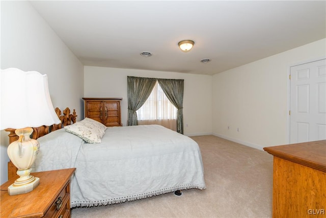 bedroom with visible vents, light carpet, and baseboards