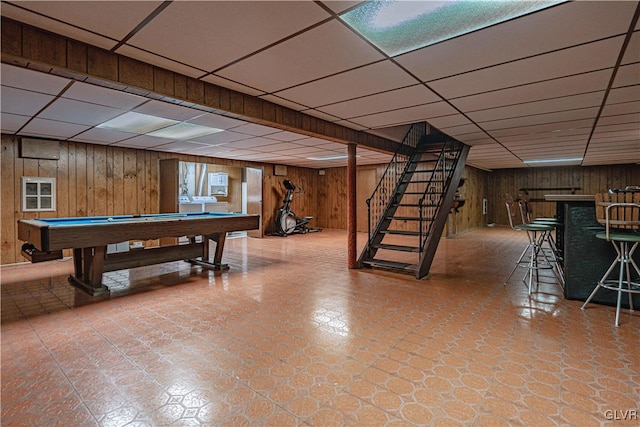 playroom with wooden walls, a drop ceiling, a bar, pool table, and tile patterned floors