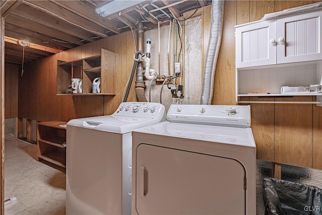 washroom with laundry area, wooden walls, and separate washer and dryer