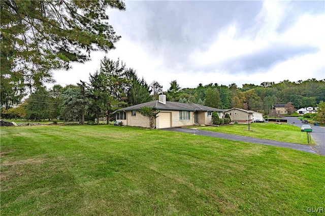 view of yard with a garage and driveway