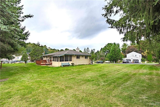 view of yard featuring a wooden deck and a sunroom