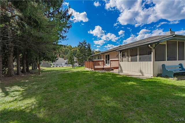 view of yard featuring a wooden deck and a sunroom