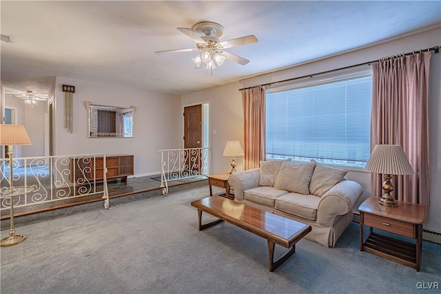 carpeted living room with a baseboard heating unit, a ceiling fan, visible vents, and baseboards