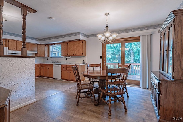 dining room with an inviting chandelier, baseboards, and light wood-type flooring