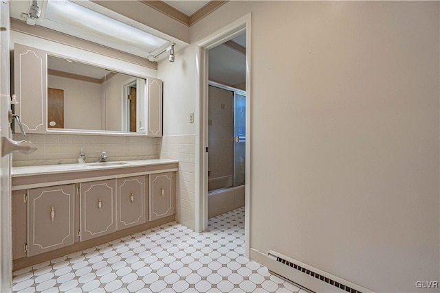 bathroom with tile patterned floors, a wainscoted wall, tile walls, baseboard heating, and vanity