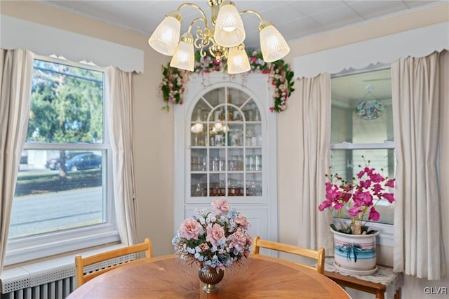 dining area featuring radiator heating unit, an inviting chandelier, and ornamental molding