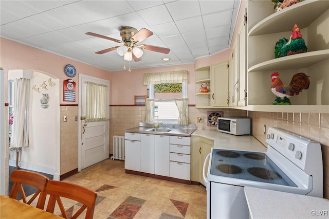 kitchen with open shelves, a sink, radiator heating unit, white appliances, and light countertops