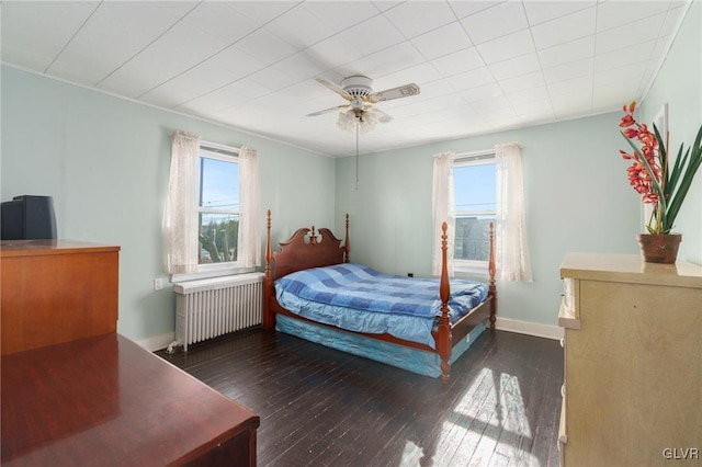 bedroom featuring baseboards, radiator, ceiling fan, and hardwood / wood-style flooring