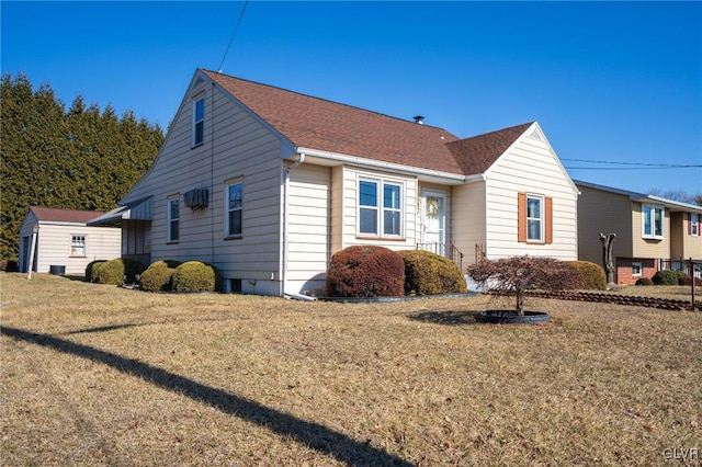 view of front of house with a front lawn and a shingled roof