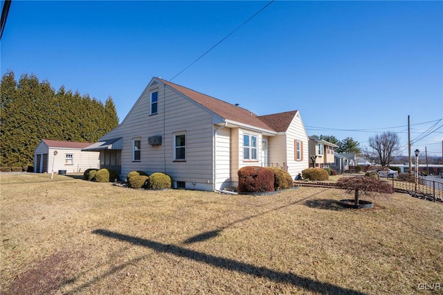 view of home's exterior featuring a lawn and fence