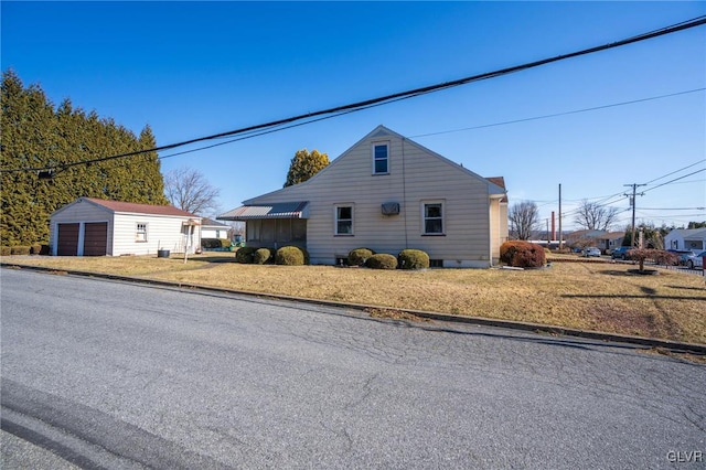 view of home's exterior featuring a garage, an outbuilding, and a yard