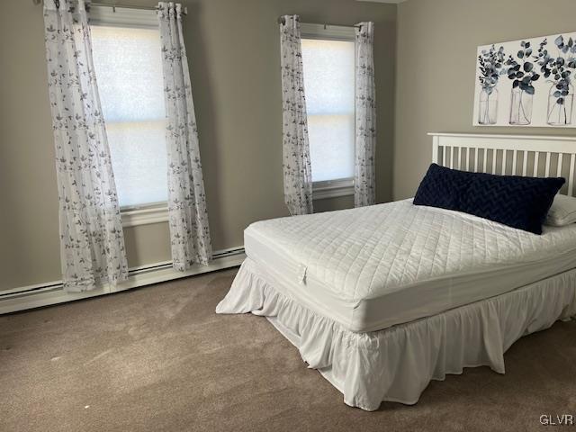 carpeted bedroom featuring baseboard heating