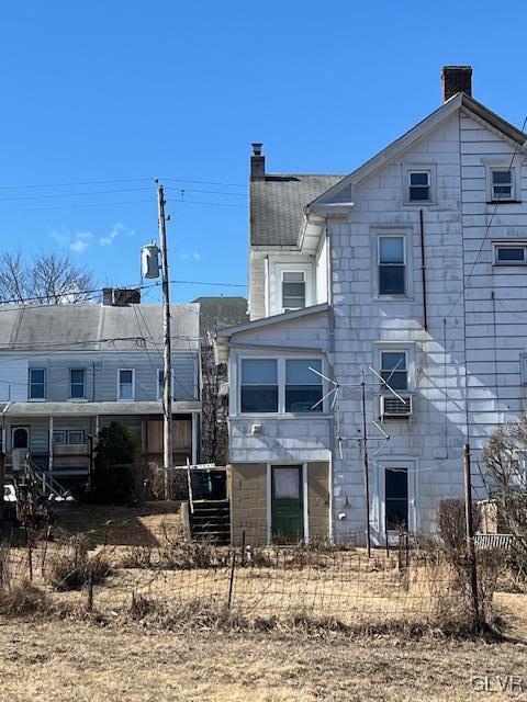 back of property with a chimney