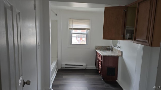 bathroom with baseboard heating, wood finished floors, and vanity