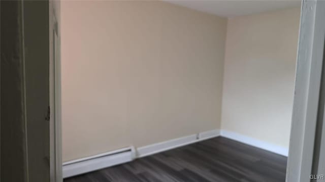 unfurnished room featuring baseboards, dark wood-style flooring, and a baseboard radiator