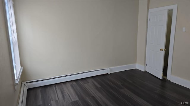 empty room featuring baseboards, dark wood-type flooring, and baseboard heating