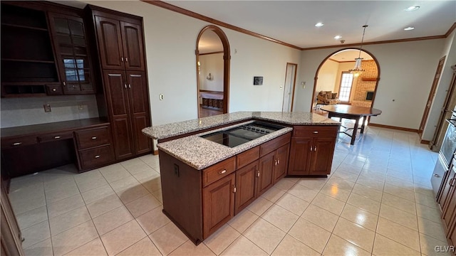 kitchen featuring light stone counters, a center island, arched walkways, light tile patterned flooring, and crown molding