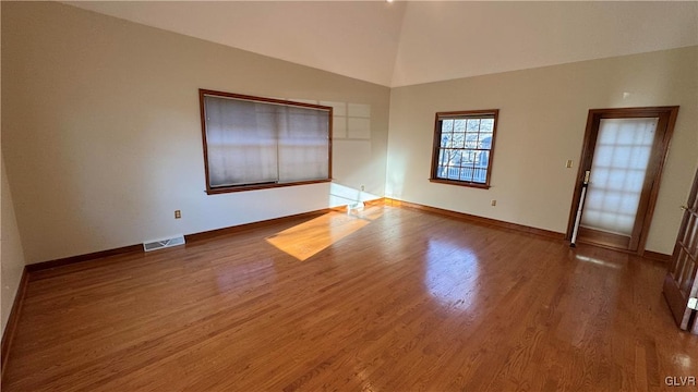 empty room with visible vents, baseboards, and wood finished floors