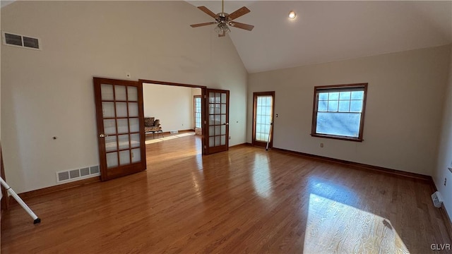 spare room with french doors, high vaulted ceiling, visible vents, and wood finished floors